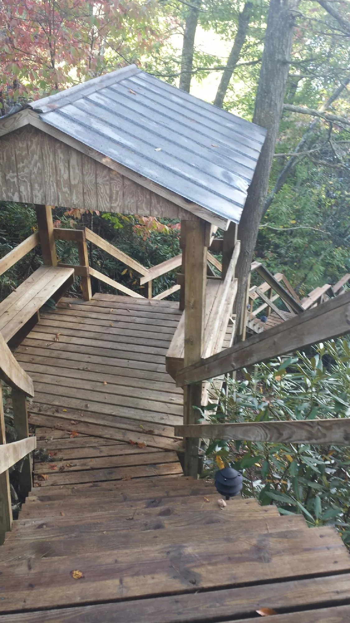 Metal roofed shelter over wooden steps on a wooded walkway — Skylight Repair & Installation work by our crew in North Little Rock