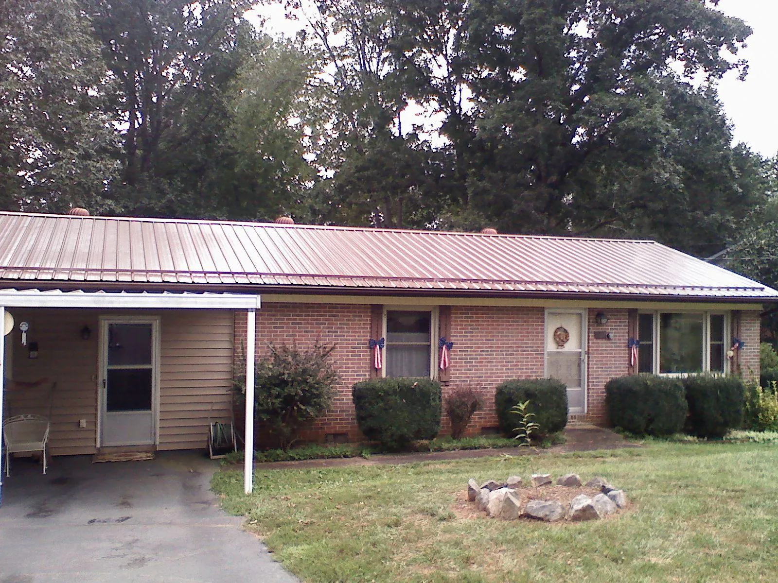 Bronze metal roof and carport on a brick ranch home — Roof Repair work by our crew in North Little Rock