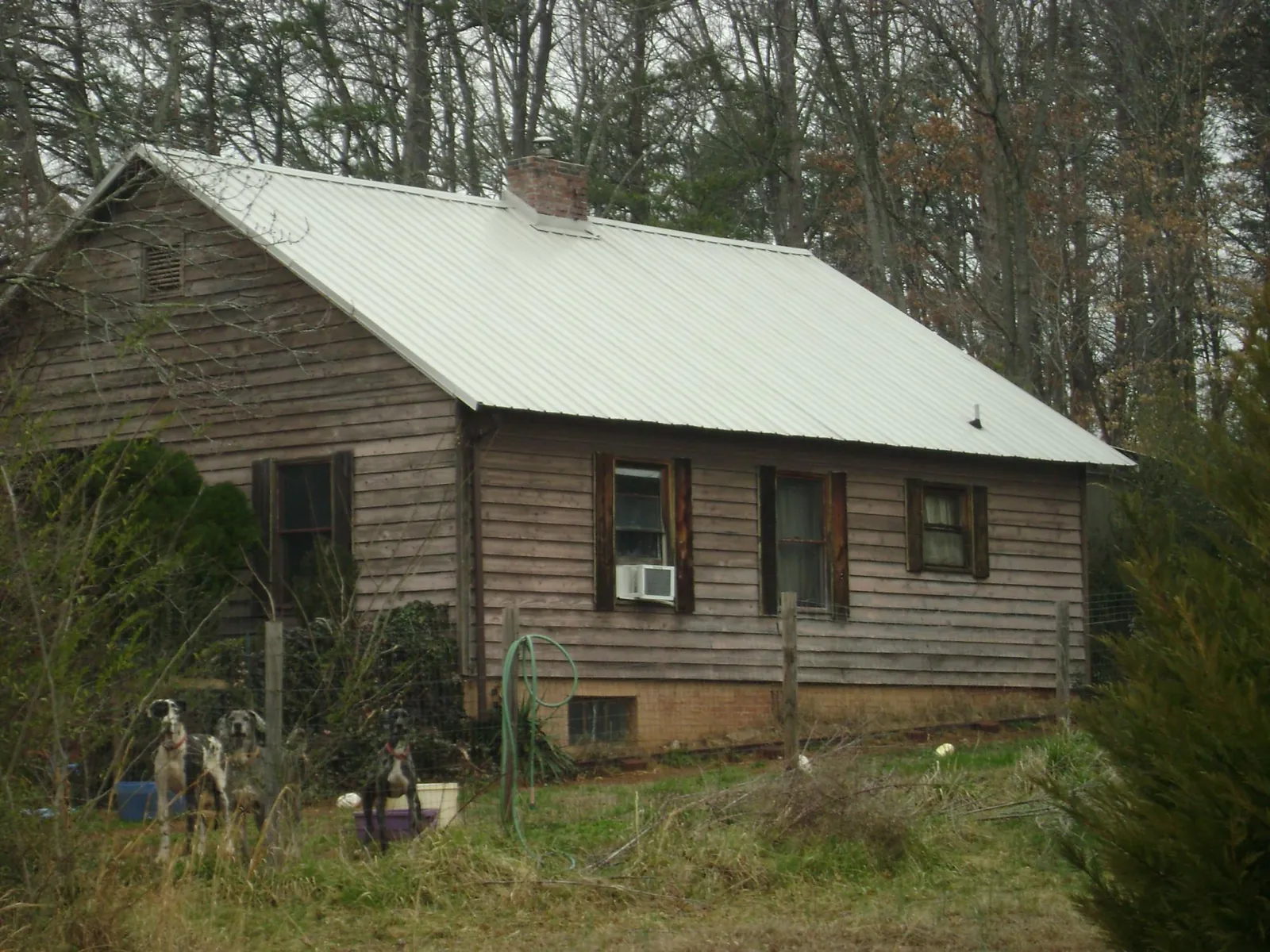 White metal roof on an old wood sided farmhouse, from a Asphalt Shingle Roof Repair job in North Little Rock